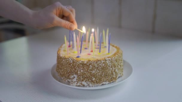 Manos encendiendo velas de pastel de cumpleaños. Vela ligera de la mano de la persona del primer plano para la celebración — Vídeos de Stock