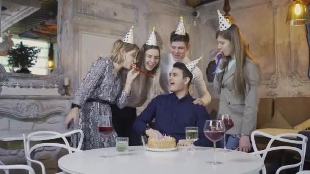 O aniversariante gosta de comemorar com seus melhores amigos soprando uma vela de bolo e recebendo presentes de amigos. — Vídeo de Stock