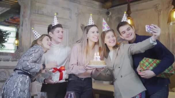 Η εορτάζουσα είναι στην ευχάριστη θέση να γιορτάσει τα γενέθλιά της με τις καλύτερες φίλες της. Το κορίτσι κάνει μια κοινή selfie στο τηλέφωνό της με τους φίλους της — Αρχείο Βίντεο