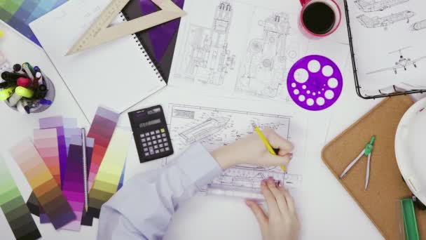 Draufsicht einer Designerin, die Zeichnungen auf einem Lineal zeichnet, das in einer Kreativwerkstatt arbeitet — Stockvideo