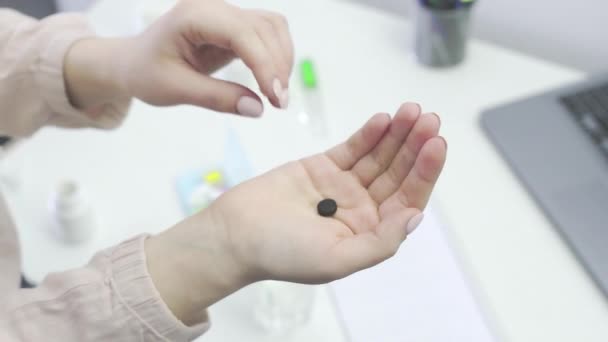 Una chica irreconocible toma pastillas de su mano y las lava con agua, de cerca — Vídeos de Stock
