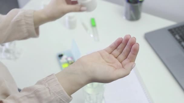 An unrecognizable girl takes pills from her hand and washes them down with water, close-up — Stock Video