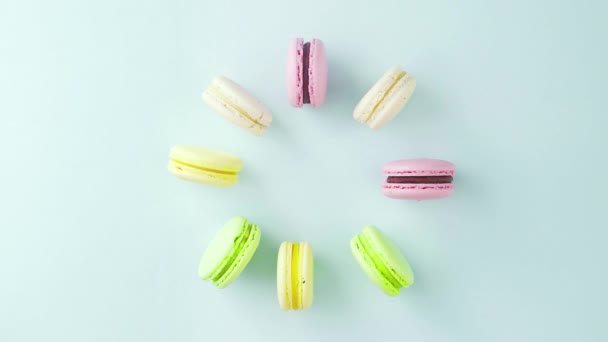 Vue de dessus des biscuits Macarons français multicolores et une tasse de café sur un fond bleu pastel — Video