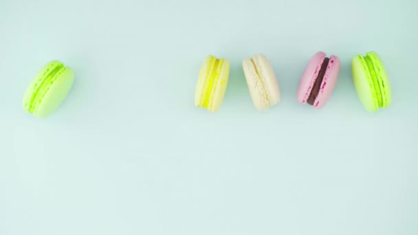 Vista dall'alto dei biscotti macaron francesi multicolori e una tazza di caffè su uno sfondo blu pastello — Video Stock