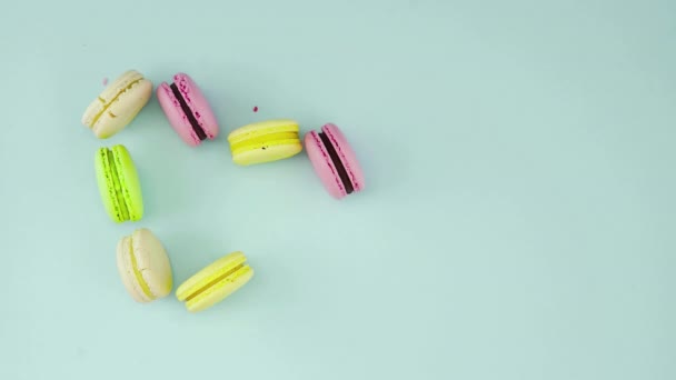 Draufsicht mit bunten französischen Macarons in Herzform auf pastellblauem Hintergrund — Stockvideo