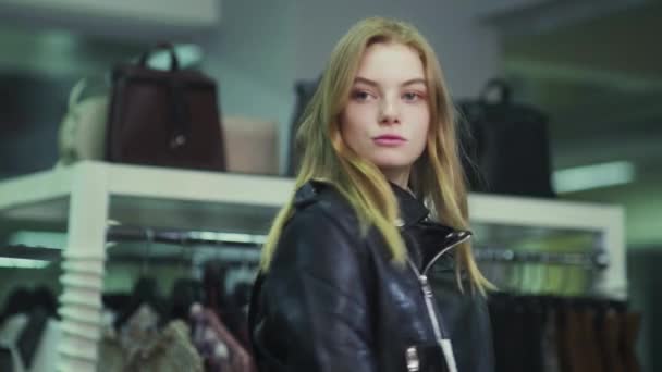 可愛い女の子が衣料品店で服を試着している。ショッピング — ストック動画