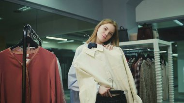 Güzel bir kız giyim mağazasında elbise deniyor. Alışveriş.