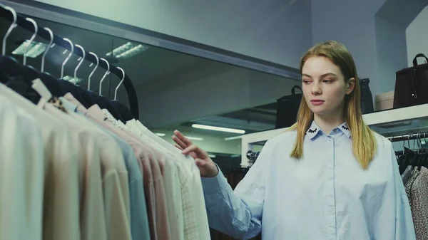 A cute girl chooses clothes in a store. Shopping — Stock Photo, Image