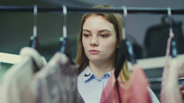 A cute girl chooses clothes in a store. Shopping — Stock Photo, Image