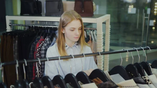 Une jolie fille choisit des vêtements dans un magasin. Shopping — Photo