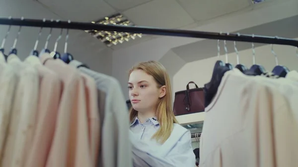 A cute girl chooses clothes in a store. Shopping — Stock Photo, Image