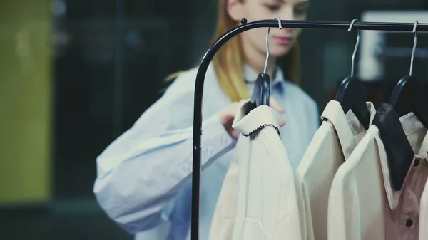 A cute girl chooses clothes in a store. Shopping — Stock Photo, Image