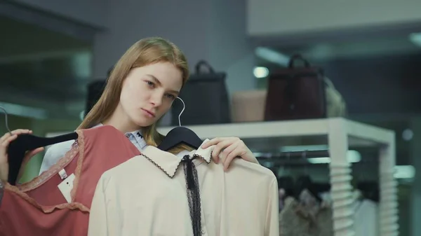 En söt flicka provar kläder i en klädaffär. Shopping — Stockfoto