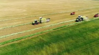 Tarlada çalışan traktör ve kamyonun kuş bakışı görüntüsü.