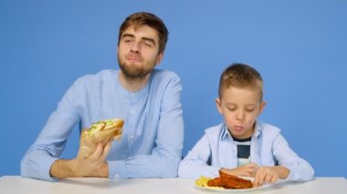 Genç bir adam ve bir çocuk masada oturuyorlar, adam çocuğun fast food yemesine izin vermiyor. Sağlıklı ve sağlıksız gıda kavramı. Fast food