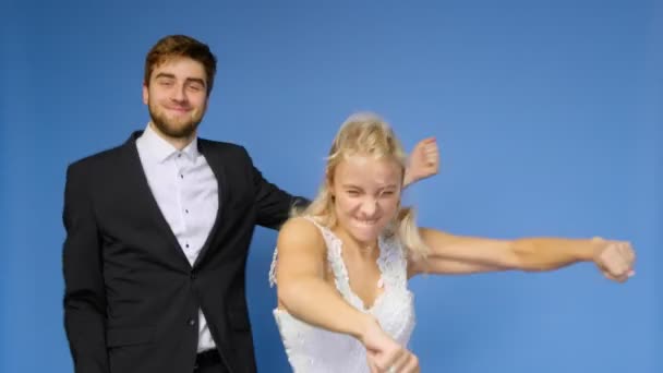 Les mariés en costumes de mariage dansent sur un fond bleu. Mariage — Video