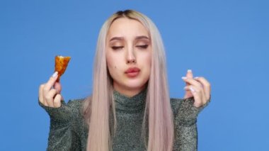 Güzel bir kızın yakın çekimi, seksi, mavi arka planda fast food yiyor. Diyet olsun. Sağlıklı ve sağlıksız gıda kavramı. Fast food