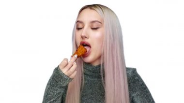 Beyaz bir arka planda cinsel açıdan fast food yiyen güzel bir kızın yakın çekimi. Diyet olsun. Sağlıklı ve sağlıksız gıda kavramı. fast food