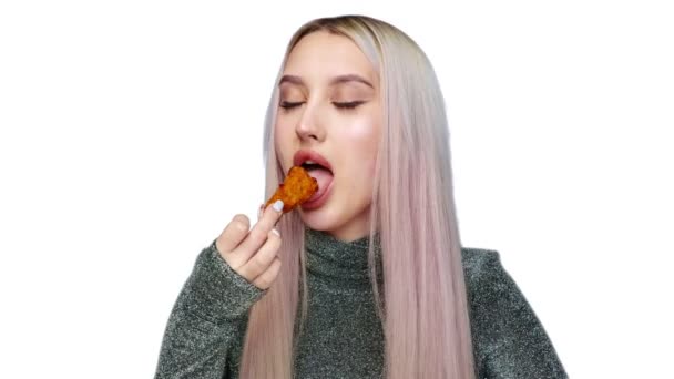 Close-up of a beautiful girl sexually eating fast food on a white background. Diet. The concept of healthy and unhealthy food. fast food — Stock Video