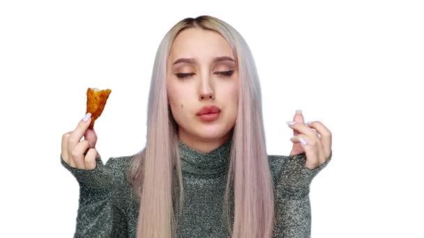 Primo piano di una bella ragazza che mangia sessualmente fast food su uno sfondo bianco. Dieta. Il concetto di cibo sano e malsano. fast food — Video Stock