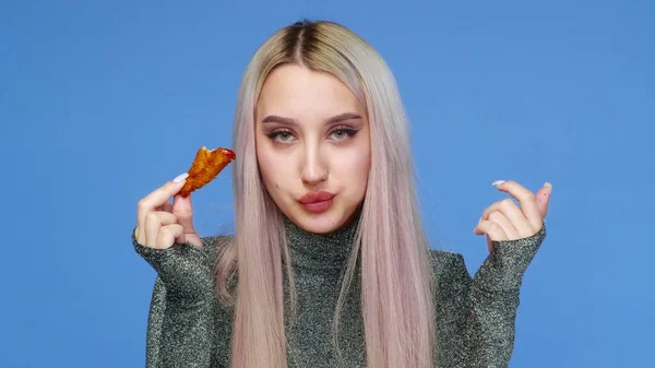 Nahaufnahme eines hübschen Mädchens, das sexy Fast Food auf blauem Hintergrund isst. Ernährung. Das Konzept der gesunden und ungesunden Ernährung. Fast food — Stockfoto
