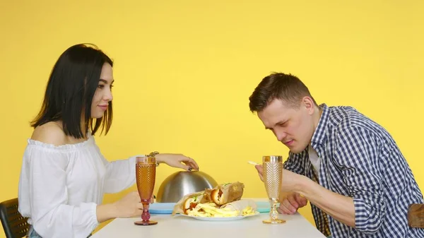 Ein Kerl und ein Mädchen bei einem Date, der Kerl ist nicht begeistert von ungesundem Essen. Datum des. Das Konzept der gesunden und ungesunden Ernährung. Fast food — Stockfoto