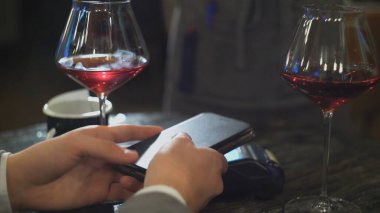 Bir kadınla randevuya çıkan bir adam, NFC 'nin yakın plan çekimini kullanarak bir lokantada ya da kafede faturasını öder.