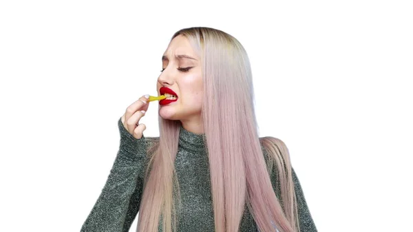 Close-up de uma menina pinta os lábios com batom vermelho e começa a comer um hambúrguer com prazer em um fundo branco. Dieta. O conceito de comida saudável e insalubre. fast food — Fotografia de Stock
