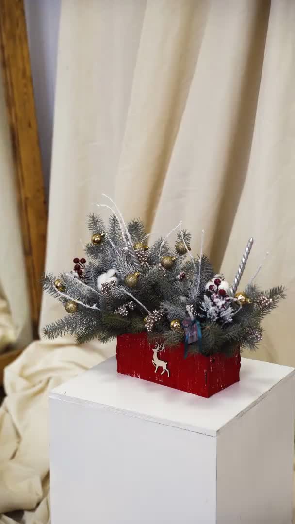 Verticale video: Een pot met een kleine kerstboom op een houten statief. Winter festival — Stockvideo