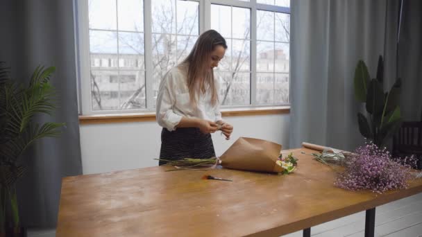 Mladá krásná žena zabývající se floristií začne sbírat nejlepší květiny pro její květinové aranžmá. Floristry — Stock video