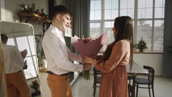 Een jonge man geeft bloemen aan zijn vriendin. Romantiek — Stockfoto