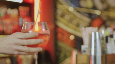 Barmenlerin eli bar masasına yakın plan bir kız için kokteyl koyar.