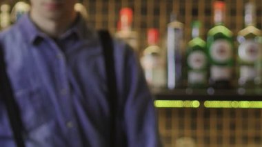 Barmen bir bardak getirdi, alkollü bir kokteyl, ve tezgahın üzerine koydu. Yakın plan.