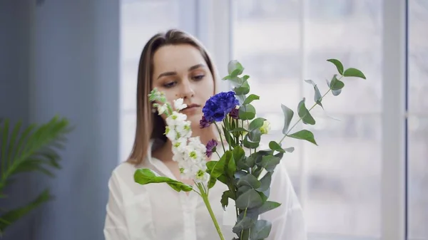Молодая красивая женщина, занимающаяся флористикой, начинает собирать лучшие цветы для своей цветочной композиции. Флористика. Крупный план — стоковое фото