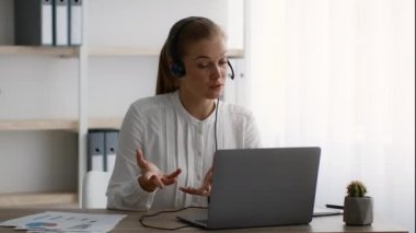 Çevrimiçi Toplantı. Kulaklık takan iş kadını laptopta ofiste video konferansı yapıyor.