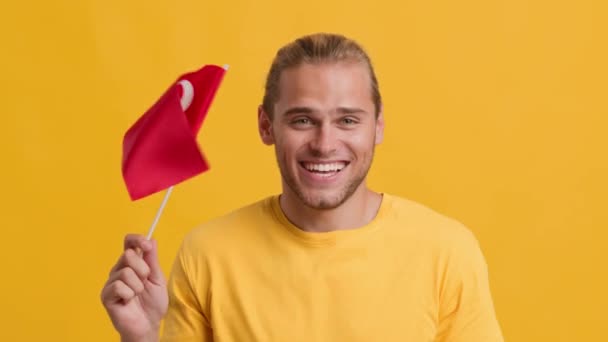 Happy young patriotic guy waving with flag of Turkey at camera — Stock Video