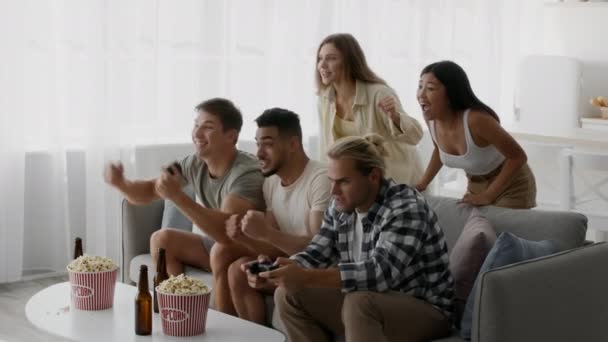 Группа молодых многонациональных друзей, играющих в видеоигры дома — стоковое видео