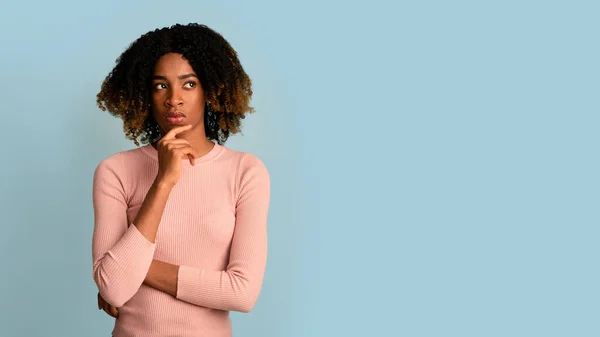 Retrato de una mujer negra pensativa tocando la barbilla y mirando a un lado, considerando opciones — Foto de Stock