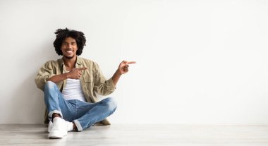 Şuraya bak. Neşeli siyahi adam, yerde oturuyor ve onu işaret ediyor.