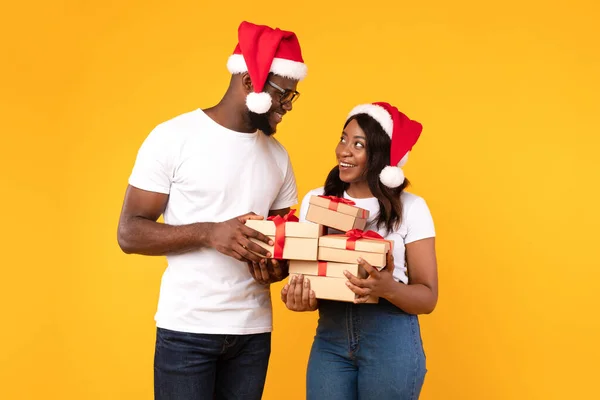 African American Ζευγάρι κρατώντας Χριστουγεννιάτικα δώρα κουτιά πάνω από κίτρινο φόντο — Φωτογραφία Αρχείου