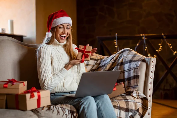 Happy Woman Holding hediye kutusu video görüşmesi için dizüstü bilgisayar kullanıyor — Stok fotoğraf
