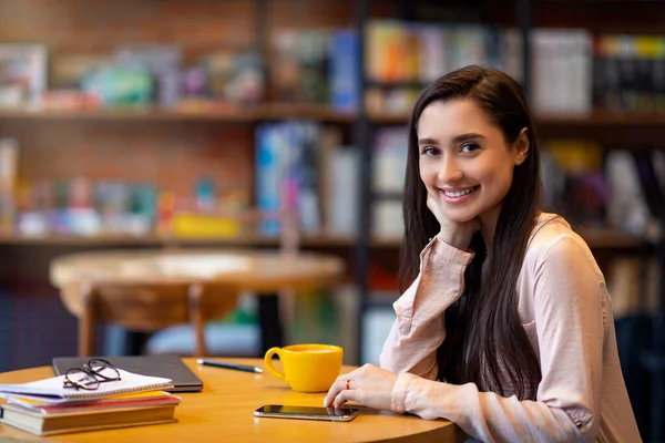 Güzel bir Arap kadının sabah kahvesinin tadını çıkarırken uzak bir çalışma odasında ya da kafede otururken çekilmiş portresi. — Stok fotoğraf
