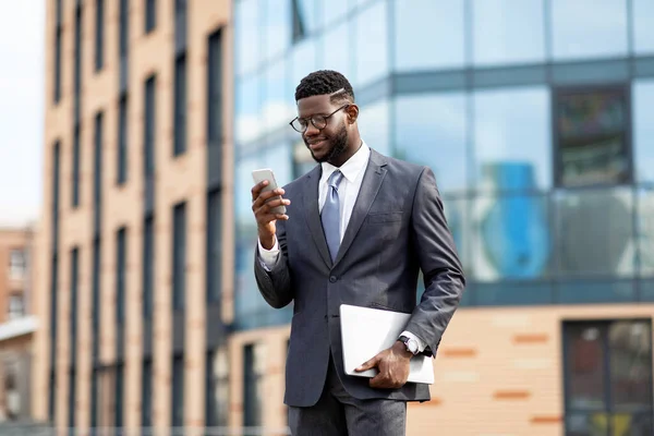 Glad afrikansk amerikansk entreprenör kontrollera e-post på mobiltelefon, har paus, promenader utomhus — Stockfoto