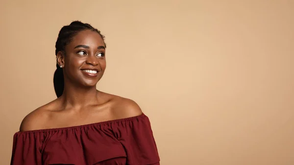 Mooie afro-Amerikaanse vrouw op zoek naar kopieerruimte en glimlachen — Stockfoto