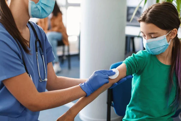 Tiener patiënt voor te bereiden om te krijgen gevaccineerd, arts desinfecteren huid — Stockfoto