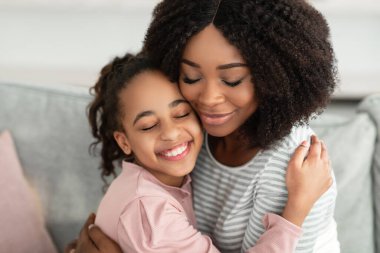 Mutlu siyah anne ve kızının yakın plan portresi.
