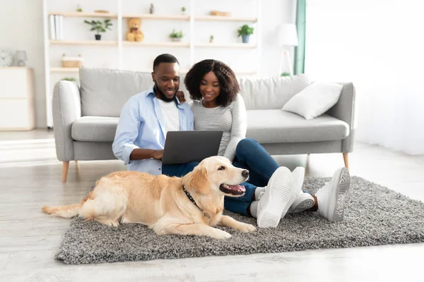 Couple noir à la maison en utilisant un ordinateur portable relaxant avec chien — Photo