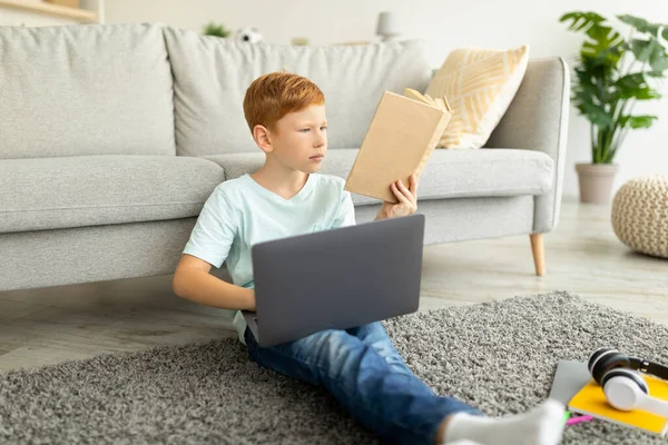 Молодой студент рыжий мальчик с ноутбуком делает домашнюю работу дома — стоковое фото