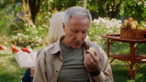 Szoros lövés idősebb házastársak pihentető szabadban őszi kertben — Stock videók
