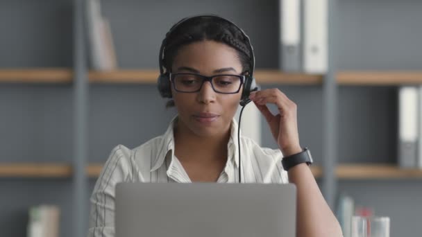 Vreemde taal sprekende club. jong afrikaans amerikaanse vrouw student dragen headset video chatten met tutor — Stockvideo